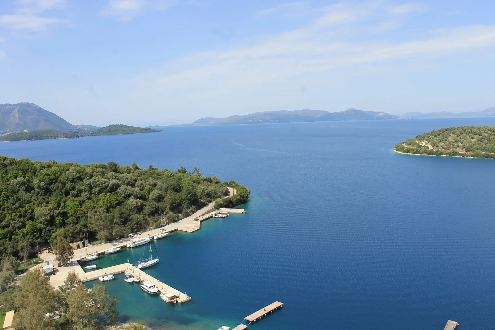 The small harbour of Spilia on Meganisi, with wooded headlands and the open Ionian beyond